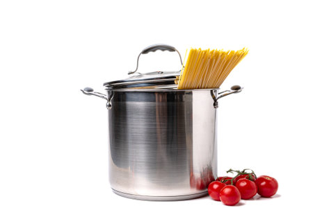 Tall stainless steel pot with pasta and tomatoes on white background.の写真素材