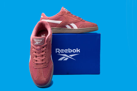 Reebok brand sneakers and box on blue background.のeditorial素材