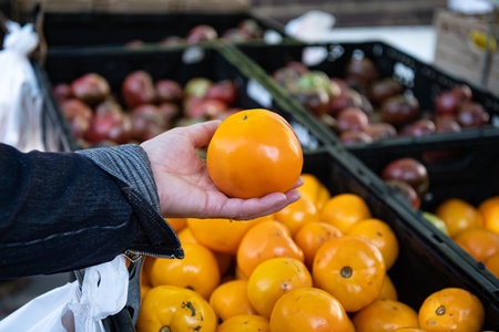 woman buys tomatoes at a local vegetable market.の写真素材