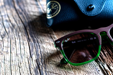 Ray Ban sunglasses case with the company brand logo and a pair of sunglasses with green frames.のeditorial素材