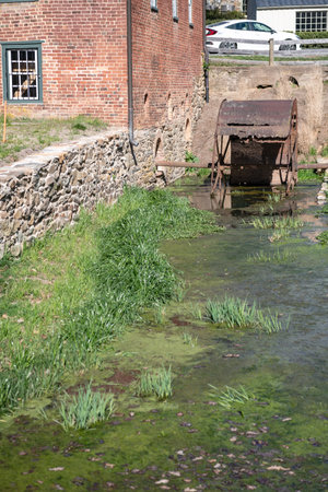 the wheel of an old water mill. The rusty metal of broken blades.の写真素材
