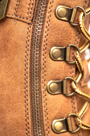 Brown leather boot with rivets, laces and zipper. Casual urban footwear. leather texture. Macro shot.の写真素材