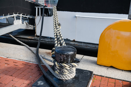 Mooring bollard with rope at the pier of Boltimore's inner harbor.