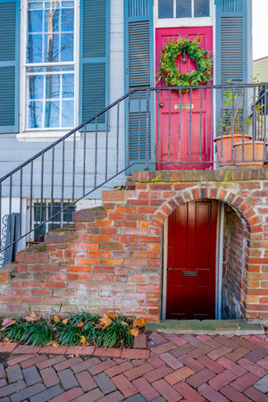 Christmas wreath on the red front door of a house.