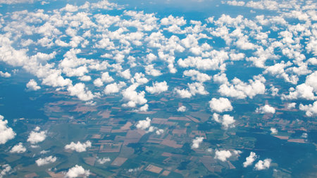 View of clouds from above with shadows on the ground.