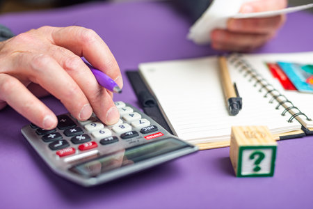 man doing calculations on a calculator to file a tax return.の写真素材