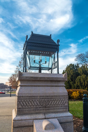 street lamp mounted on a granite pedestal against a blue sky.の写真素材