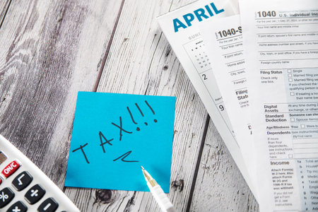 Filling out tax form. Calculator, coins, glasses, form and pen on desk.