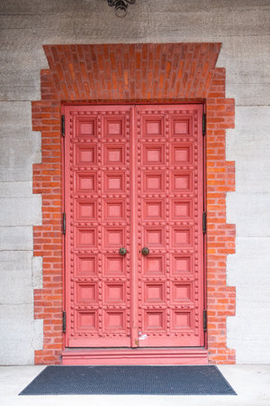 red wooden double gates in a stone wallの写真素材