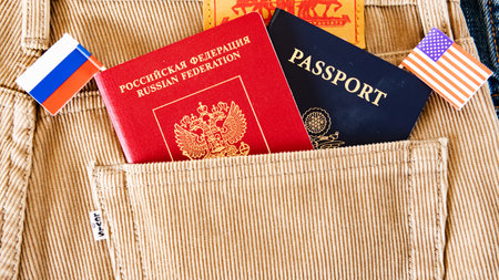 American and Russian passports with flags sticking out of the pocket of jeans.の写真素材