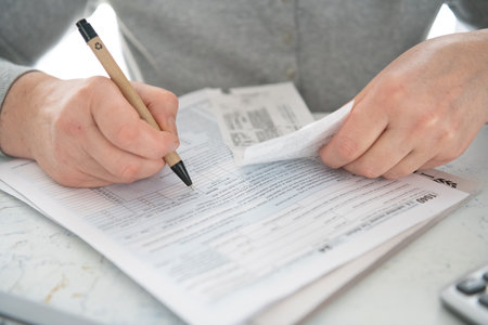 woman fills out a tax form at home.の写真素材