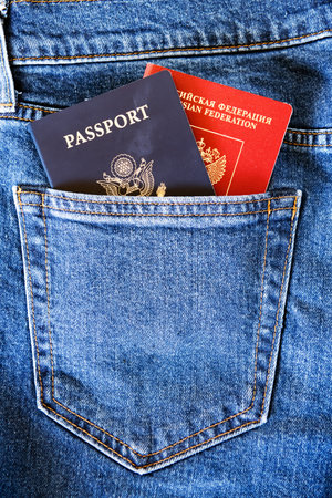 dual citizenship - American and Russian, US and Russian passports sticking out of pocketのeditorial素材