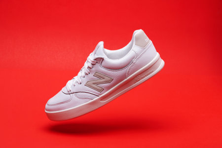 New Balance 300. White athletic sneakers levitating above red background.のeditorial素材