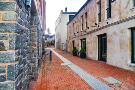 Narrow paved brick street between brick houses.の写真素材