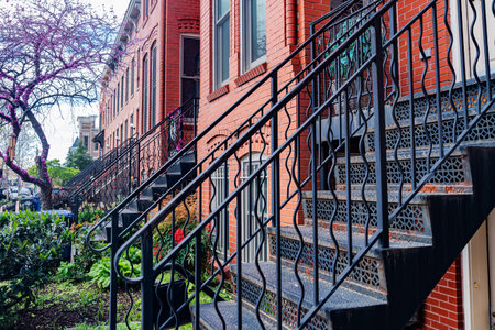 Metal ornate staircase with railing at the entrance to townhouse.