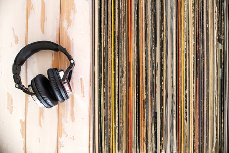 Audio equipment and classic records. Headphones lying by the stack of vinyl.