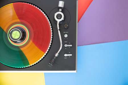 Top view of a record player. Rainbow vinyl record on the player.
