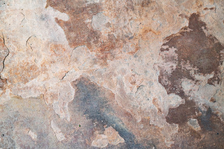 Macro view of textured rock surface with oxidized patterns, cracks, and rugged stone details.