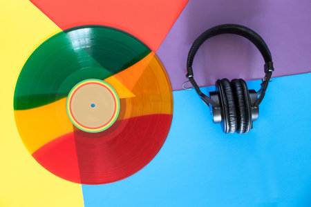 Modern hi-fi headphones with stylish green-orange-red vinyl discの写真素材