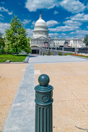 The US Capitol, with a fence post in the foreground against a bright summer sky.の写真素材