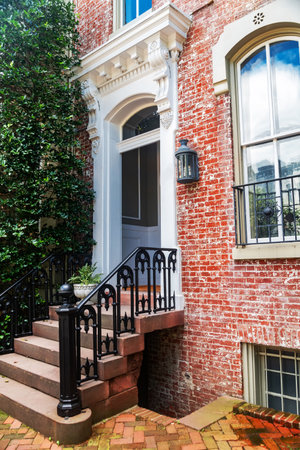 Red brick facade and vintage black iron fence in fall