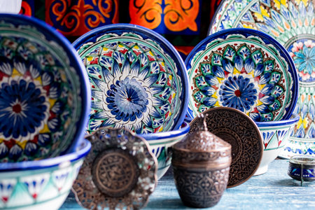 Close-up of colorful hand-painted oriental dishes on a window-lit background.の写真素材