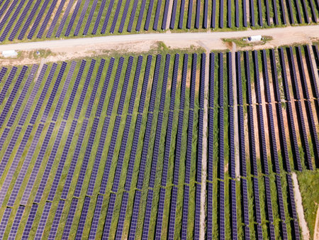 Aerial view of solar panel farm with perfectly aligned rows of photovoltaic cells