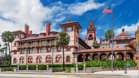 Spanish-style university architecture with palm trees and American flag