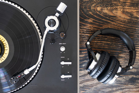 High fidelity turntable in motion with detailed tonearm view. next to the headphones.の写真素材