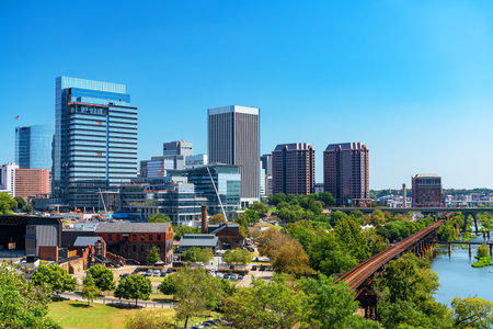 Scenic outdoor shot of Richmond's urban development alongside nature, with lush trees and a prominent curved railway leading into the city center.の写真素材