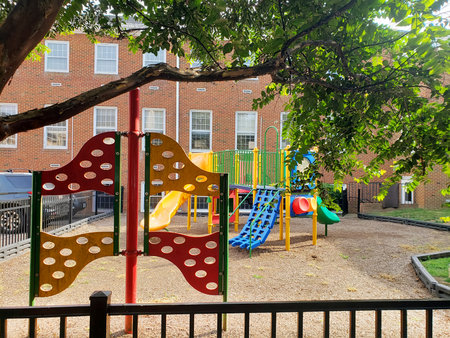 Colorful playground with slides and climbing structure in residential courtyard