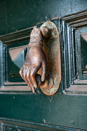 Ornate metal hand door knocker with vintage patinaの写真素材