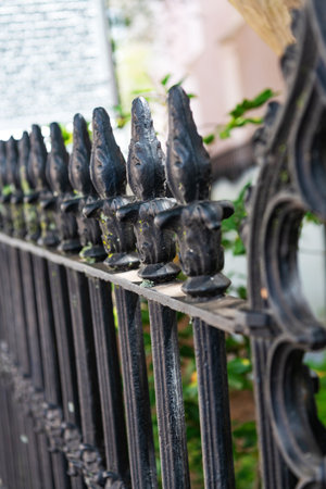 Ornate wrought iron fence with decorative pointed finials in shallow depth of fieldの写真素材