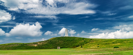 Wright Brothers National Memorial on grassy hill under dramatic blue skyの写真素材