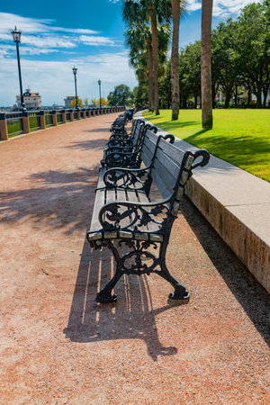 Empty Ornate Park Benches Lining Waterfront Promenade in Charleston, South Carolinaの写真素材
