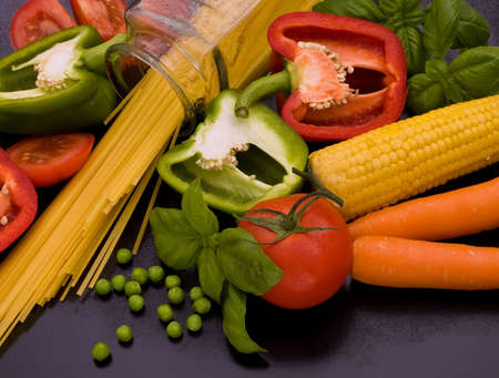 An arrangement of fresh vegetables with pasta on a black background. の写真素材