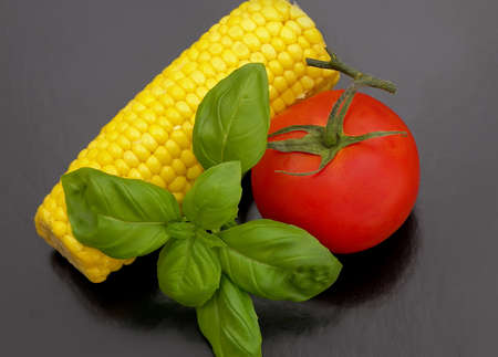 Sweet-corn with tomato and basil.の写真素材