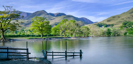 The head of Buttermere Lake in Cumbria, showing the surrounding mountains and calm water.