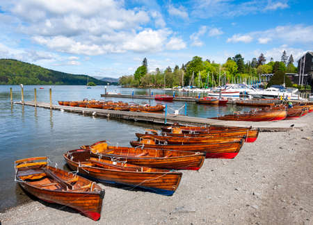 A large number of rowing boats lined up by Derwent water in Keswick. Lake side view of rowing boats ready for tourists.の写真素材