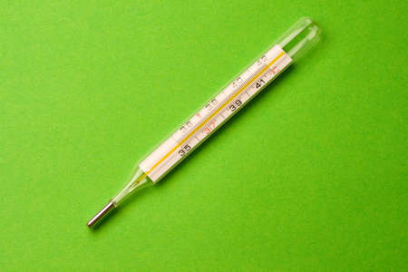 Thermometer isolated on the green background の写真素材