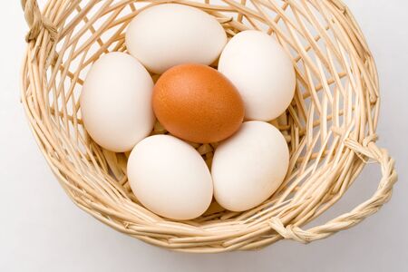 Eggs in basket isolated on white の写真素材
