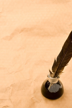 Feather and ink bottle isolated on paper backgroundの写真素材