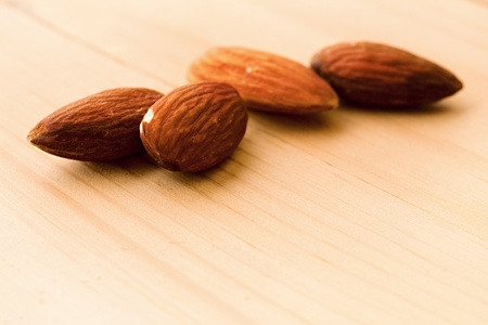 Almonds isolated on wooden backgroundの写真素材