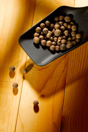 Spoon and pepper isolated on wooden backgroundの写真素材