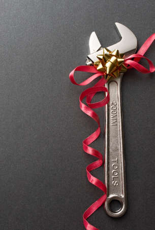 Spanner with ribbon on the grey backgroundの写真素材