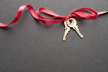 Keys with ribbon on the grey backgroundの写真素材