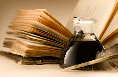 An old book with a feather and the inkpot full of ink の写真素材
