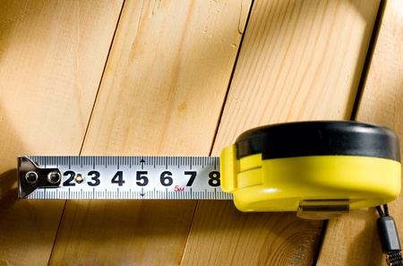 Tape measure on a wooden background 