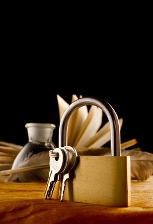 A feather, inkpot, old book and keylockの写真素材