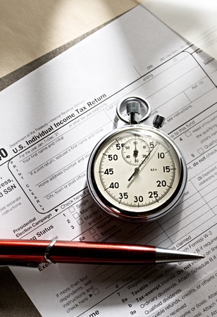 Tax form, red pen and stopwatchの写真素材